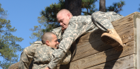 Army soldiers climbing wall obstacle