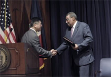 Locke and Delatour on stage shaking hands. Click for larger image.