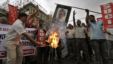 Activists of Socialist Unity Center of India (SUCI) burn an effigy with a portrait of Indian Prime Minister Manmohan Singh during a protest in Kolkata, India, September 15, 2012.