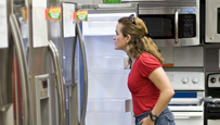 Photo of a woman shopping for a refrigerator.