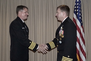 Navy Reserve Cmdr. Lowen Loftin (left), incoming commanding officer of U.S. Transportation Command's Joint Transportation Reserve Unit, wishes outgoing commanding officer, Capt. Mark Leavitt, 