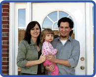 Smiling family in front of their house