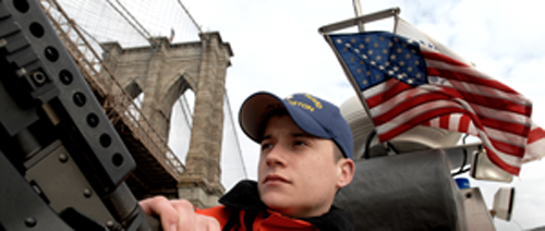 Member of Maritime Safety and Security Team 91110 out of Boston, looks out onto the East River during an early morning security patrol.