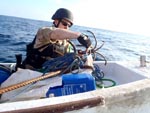 The boarding crew from USS Laboon dispose of items from a pirate skiff as used by somali pirates.