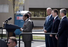 Hightower on podium with Biden and others behind. Click for larger image.