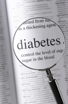 Photo of the word “diabetes” and surrounding text seen through a magnifying glass.