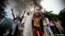Sudanese demonstrators stand in front of the burning German embassy in Khartoum (REUTERS/Mohamed Nureldin Abdallah)