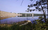 An image of McGee Creek Reservoir in Oklahoma showing a portion of the dam, reservoir and the intake for a municipal water pipeline.