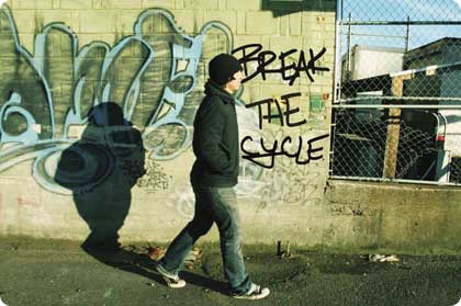 photo of a young offender walking along the streets with a wall covered in graffiti in the background – for SAMHSA News story on CSAT and YORP programs