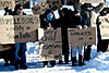 [Photo: Volunteers holding cardboard signs 'Homelessness a reality in Sioux Falls' and 'Every child deserves a warm bed']