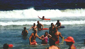 swimmer being rescue from rip at crowded beach