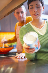 A woman checks the label on a can.