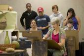 Group looking over teacher's shoulder in art class