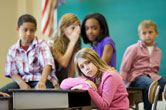 A girl is bullied by others in the classroom. 