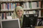 Woman smiling from behind computer