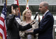 Locke, Kimball and Kappos with hand on Bible, taking oath of office. Click for larger image.