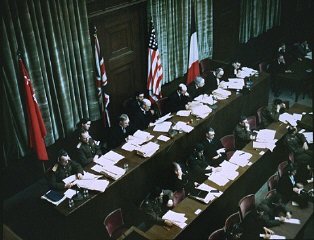 The International Military Tribunal was a court convened jointly by the victorious Allied governments.  Here  the Soviet, British, American, and French flags hang behind the judges' bench.