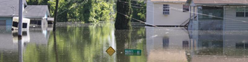 August 29th, 2005. Standing water floods the streets of Mississippi, measuring just under street signs.