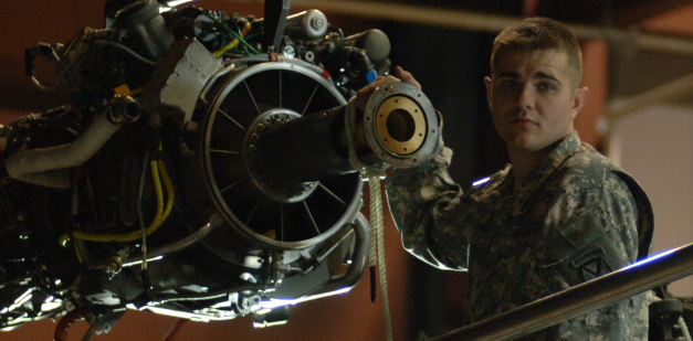 Army soldier working on aircraft engine