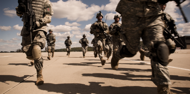 Soldiers running across flight-line