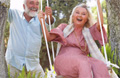 Man pushing woman in swing