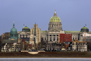 Photo of a city skyline with a capitol building surrounded by a variety of other buildings.