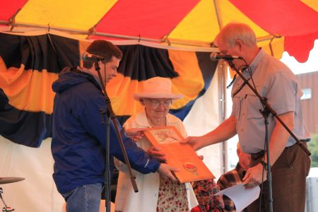 Bud Cribley and Senator Begich presenting a plaque to homesteader Elizabeth Smith 