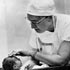 Dr. Virginia Apgar examining a newborn baby, 1950s.