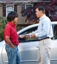 Father handing car keys to his son.