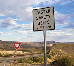 Photo: Sign saying "Fasten Safety Belts - State Law"