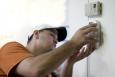 Brian Bernal installs a carbon monoxide detector for a homeowner participating in the Weatherization Assistance Program in Loveland, CO. | Credit: Dennis Schroeder, NREL.