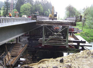 The old steel truss bridge (<em>right</em>) rests on temporary piers. The new  bridge (<em>left</em>) was built next to the structure on temporary supports.