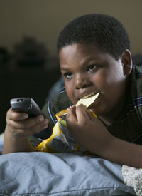 photo of child watching TV and eating