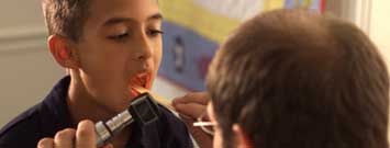 Photo: A boy having his throat examined