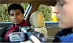 Photo: Two teen boys in a car with a video camera.