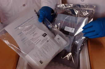 Picture of laboratory person handling packages of RT-PCR test kits.