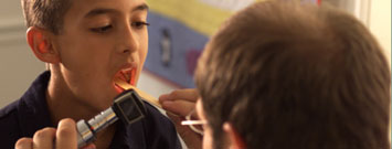 Doctor realizando un examen de garganta a un niño