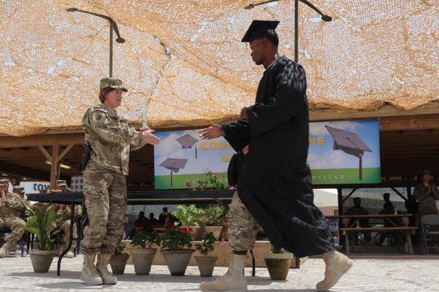 Brig. Gen. Kristin K. French, commanding general, 3rd Sustainment Command (Expeditionary), prepares to hand a diploma to Staff Sgt. Jermaine Holley, a driver with the 96th Transportation Company during the first ever Kandahar Airfield college graduation ceremony on May 23. French gave the opening remarks for the first ever Kandahar Airfield college graduation ceremony and handed out mock diplomas to graduates. (U.S. Army photo by Sgt. Gregory Williams)