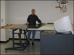 Man working at an adjustable table used to transport plates.