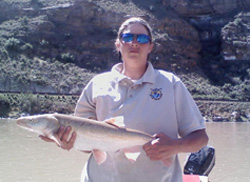 U.S. Fish and Wildlife Service Biological Technician Lindsay Lesmeister holds a 26-inch, 2 pound, adult male endangered Colorado pikeminnow captured on April 22, 2009, from the Colorado River downstream of the Grand Valley Project Diversion Dam near Grand Junction, Colorado.