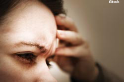 Photo of a woman holding her head in pain