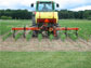 A farmer on a tractor tending to an agricultural crop.