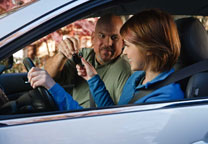 Father giving keys to his daughter in a car