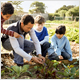 African-American man showing children how to garden