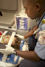 Woman on backboard inside an ambulance being treated by EMS