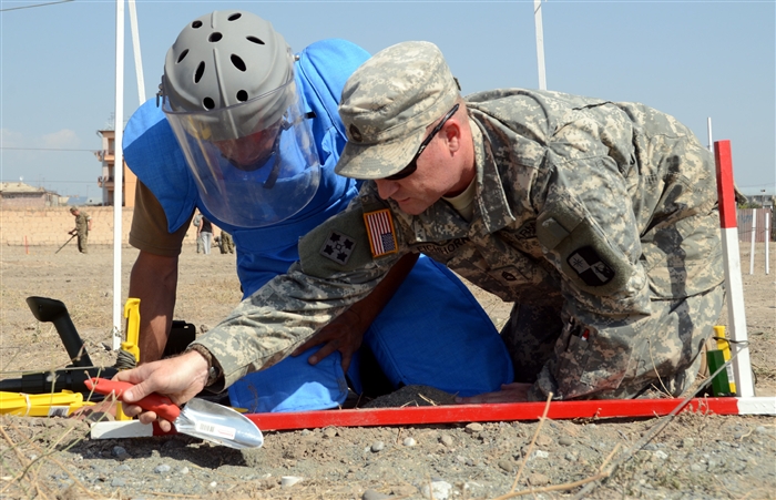 Sgt. 1st Class Travis Eichhorn, a Pittsburg, Kan., native and combat engineer with the Kansas National Guard, partners with a soldier from the Engineering Companies of the Armenian Peacekeeping Brigade during a simulated one-man demining drill as part of a training course taught by soldiers of the Kansas National Guard and a civilian representative from the U.S. Humanitarian Demining Training Center. Kansas National guardsmen and the HDTC representative are instructing Armenian peacekeepers and engineer battalions on international demining standards as part of the Humanitarian Mine Action program and will assist the Armenian government in developing a national standard operating procedure for demining.