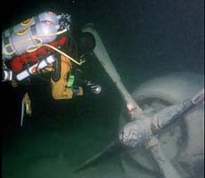 (photo) An archeologist investigates a submerged airplane. (NPS)