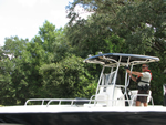 A man standing on a boat pointing a firearm