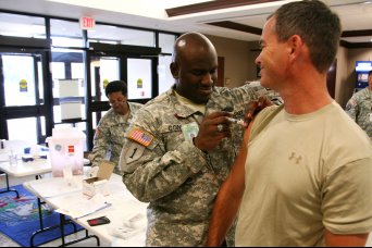 Col. Michael Yowell, G-2 office, U.S. Army Space and Missile Defense Command/Army Forces Strategic Command, receives his flu shot from Sgt. Jerome Cone, medic, Fox Army Health Clinic, Sept. 25 at the command's Redstone Arsenal location.