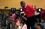 On April 3, 2008, Foster Grandparent Enoch Nelson works with students on their computer skills at St. Paul Primary School in Summerton, South Carolina.